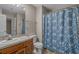 Neutral bathroom features a wooden vanity with granite countertop and blue floral shower curtain at 900 Courtyard Dr. # K7, Myrtle Beach, SC 29577