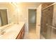 Bathroom featuring a shower with glass door, double vanity, and tile floor at 908 Hornbeam Ct., Loris, SC 29569