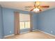 Bedroom with blue walls featuring a ceiling fan, window with blinds and neutral colored curtains at 908 Hornbeam Ct., Loris, SC 29569