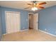 Bedroom with blue walls featuring a ceiling fan and double door closet at 908 Hornbeam Ct., Loris, SC 29569