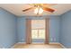 Bedroom with blue walls featuring a ceiling fan, window with blinds and neutral colored curtains at 908 Hornbeam Ct., Loris, SC 29569