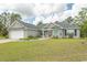 Well-maintained one-story home with light gray siding, a red front door, and a spacious front yard at 908 Hornbeam Ct., Loris, SC 29569