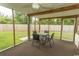 Screened porch featuring a table and four chairs, ceiling fan, and view of backyard at 908 Hornbeam Ct., Loris, SC 29569