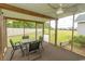 Screened porch featuring a table and four chairs, ceiling fan, and view of backyard at 908 Hornbeam Ct., Loris, SC 29569