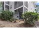 Exterior shot of the screened-in back porch with outdoor furniture and landscaped yard at 9550 Dunes Gable Dr. # A, Myrtle Beach, SC 29572