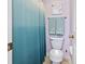 Clean bathroom featuring a toilet, a shower with a curtain, and a 