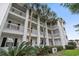 Exterior shot of a multi-story condo with balconies and mature palm trees at 9550 Dunes Gable Dr. # A, Myrtle Beach, SC 29572