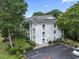 Aerial view of the white-sided condo building with black top parking and some green space at 9550 Dunes Gable Dr. # A, Myrtle Beach, SC 29572