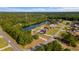 Aerial view of homes surrounded by lush trees and a large pond with neighborhood swimming pool at 101 Alpharetta Ct., Conway, SC 29526