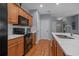 Well-lit kitchen with stainless steel appliances, light countertops and backsplash, and hardwood flooring at 101 Fulbourn Pl., Myrtle Beach, SC 29579