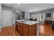 Open concept kitchen island with sink and faucet, light countertops, and hardwood flooring leading into the dining area at 101 Fulbourn Pl., Myrtle Beach, SC 29579