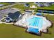 Aerial view of a large community pool with beach chairs, landscaping, tennis, and a clubhouse at 1055 Laconic Dr., Myrtle Beach, SC 29588