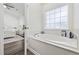 Bathroom with large tub, window, and view into the bedroom at 1127 Harvester Circle # 1127, Myrtle Beach, SC 29579