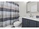 A modern bathroom features a tiled shower with curtain, stainless steel hardware, and a dark vanity at 1127 Harvester Circle # 1127, Myrtle Beach, SC 29579