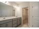 Bathroom vanity featuring double sinks, modern lighting, and linen closet at 115 Old Chimney Ln, Conway, SC 29526