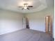Inviting bedroom showcasing tray ceiling, a ceiling fan, and ensuite bathroom access at 115 Old Chimney Ln, Conway, SC 29526