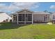 Backyard with screened-in porch, patio, and well-maintained green lawn at 133 Lakeside Crossing Dr., Conway, SC 29526