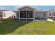 Home's backyard with a screened-in porch, patio seating, and lush green lawn at 133 Lakeside Crossing Dr., Conway, SC 29526