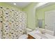 Bright bathroom featuring a shower with a dinosaur-themed curtain and a white vanity at 1439 Brighton Ave., Myrtle Beach, SC 29588