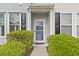 Charming front door of home with black shutters and landscaped bushes at 157 Olde Towne Way # 4, Myrtle Beach, SC 29588