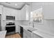Modern kitchen features stainless steel appliances, white cabinets, and a farmhouse sink at 1611A S Ocean Blvd., Surfside Beach, SC 29575