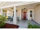 Inviting front porch with seating and a red front door at 189 Sea Turtle Dr., Myrtle Beach, SC 29588