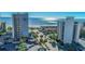 Aerial view of building with pool, palm trees and parking in front and ocean in the background on a sunny day at 200 76Th Ave. N # 408, Myrtle Beach, SC 29572
