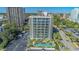 Aerial view of condo building with balconies and palm trees surrounding pool and parking lot near oceanfront at 200 76Th Ave. N # 408, Myrtle Beach, SC 29572