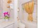 Cozy bathroom featuring a shower with decorative gold curtain and marble countertop with decorative shelves and pink flowers at 200 76Th Ave. N # 408, Myrtle Beach, SC 29572