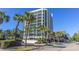 Exterior view of a tall condominium building with multiple floors and balconies, surrounded by palm trees at 200 76Th Ave. N # 408, Myrtle Beach, SC 29572