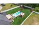 Aerial view of the backyard featuring a pool, tiki bar, hot tub, sheds, and manicured lawn at 210 Fox Hunt Pl., Aynor, SC 29511