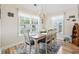 Bright dining room with a chandelier, seating for six, and natural light from large windows at 210 Fox Hunt Pl., Aynor, SC 29511