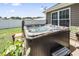 Backyard hot tub featuring steps for easy access, adjacent to a window and green foliage at 210 Fox Hunt Pl., Aynor, SC 29511
