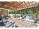 Relaxing patio with a wooden pergola, comfortable seating, and a view of the pool and backyard at 210 Fox Hunt Pl., Aynor, SC 29511