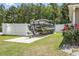 Pontoon boat parked on a concrete pad next to a white fence, with lush green grass surrounding it at 210 Fox Hunt Pl., Aynor, SC 29511