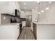 Modern kitchen with white cabinetry, gray backsplash, stainless steel appliances, granite countertops, and wood grain flooring at 2409 Thoroughfare Dr. # 2409, North Myrtle Beach, SC 29582