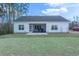 Back of house, showcasing a screened porch, patio, and well-maintained backyard at 250 Ole Maple St., Loris, SC 29569