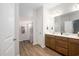 Well-lit bathroom with a shower featuring a curtain, double vanity, and wood grain floors at 250 Ole Maple St., Loris, SC 29569