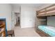 Neutral toned bedroom featuring a wooden bunk bed, plush carpet, and entry to other rooms at 250 Ole Maple St., Loris, SC 29569