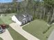 An eye-level exterior showcasing a well-manicured lawn, driveway, and the side of a white house with dark shutters and roof at 250 Ole Maple St., Loris, SC 29569