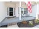 Cozy front porch with seating, an American flag, and decorative landscaping at 250 Ole Maple St., Loris, SC 29569