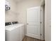 Bright laundry room with washer, dryer, storage shelf, and access to a door at 250 Ole Maple St., Loris, SC 29569