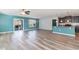 Open-concept living area with wood-look floors, sliding doors, blue accent wall, and adjacent kitchen at 2825 Mcdougall Dr., Conway, SC 29526