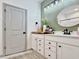 Charming bathroom featuring a white vanity, round mirror and a neutral green accent wall at 2858 Ellesmere Circle, Myrtle Beach, SC 29579