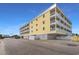 Beautiful exterior shot of a yellow condo building with large balconies under a bright blue sky at 301 N Waccamaw Dr. # 110, Murrells Inlet, SC 29576