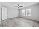 Bright bedroom with two windows, ceiling fan, neutral walls, and wood-look flooring at 3175 Lyndon Dr., Little River, SC 29566