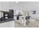 Well-lit kitchen with white cabinetry, black appliances, and a central island with bar seating at 3175 Lyndon Dr., Little River, SC 29566