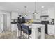 Bright kitchen featuring white cabinets, modern fixtures, and a marble-topped island with bar stools at 3175 Lyndon Dr., Little River, SC 29566