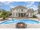 Luxury home exterior with a pool, patio, firepit, outdoor seating, and well-maintained landscaping at 3564 Brampton Dr., Myrtle Beach, SC 29588