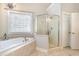 Bright bathroom featuring a soaking tub, glass shower enclosure, tile floors and natural light at 3564 Brampton Dr., Myrtle Beach, SC 29588